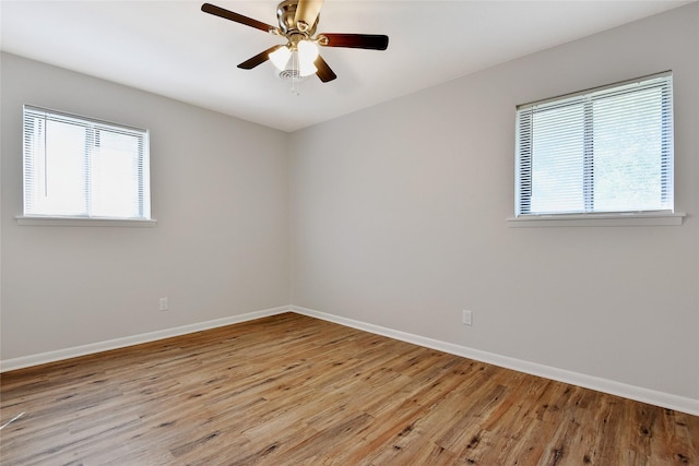 unfurnished room featuring light wood-style flooring, baseboards, and a ceiling fan