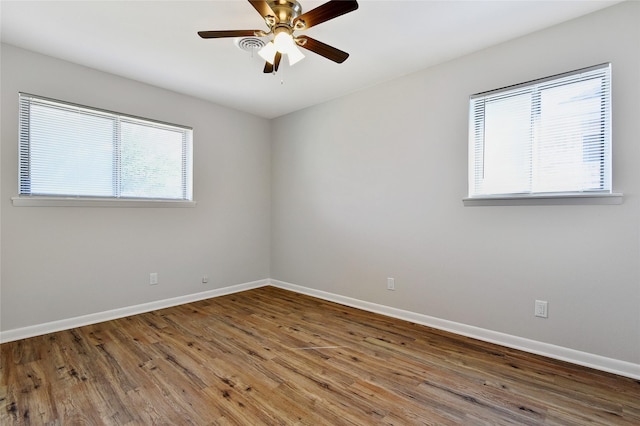 spare room with ceiling fan, wood finished floors, and baseboards