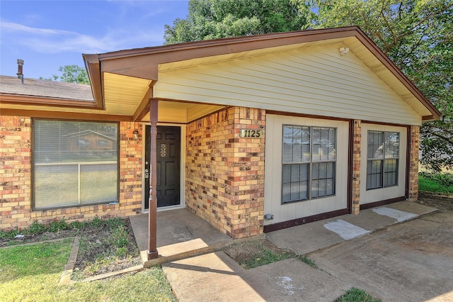 view of exterior entry with brick siding