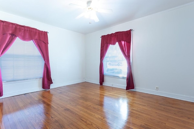 empty room with ceiling fan, baseboards, and wood finished floors