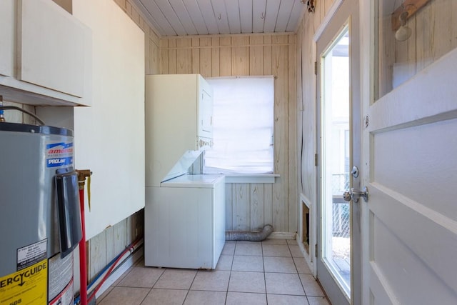 laundry area with cabinet space, light tile patterned floors, a wealth of natural light, and electric water heater