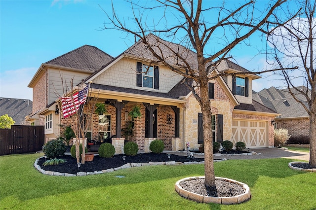 craftsman-style house featuring a front yard, fence, and brick siding