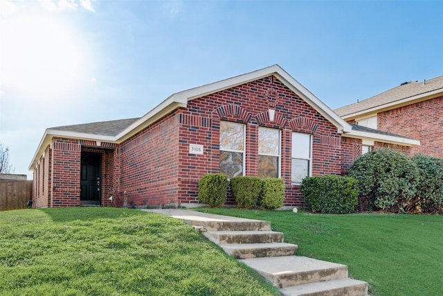 ranch-style house featuring brick siding and a front lawn