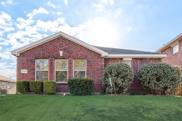 ranch-style home with central AC, brick siding, and a front lawn