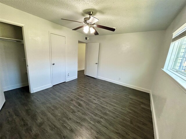 3616 Parkridge Dr Unit 108, Dallas, TX 75234 - unfurnished bedroom with dark wood-style floors, ceiling fan, baseboards, and a textured ceiling