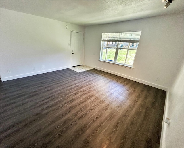 3616 Parkridge Dr Unit 108, Dallas, TX 75234 - unfurnished room featuring baseboards, dark wood-style flooring, and a textured ceiling