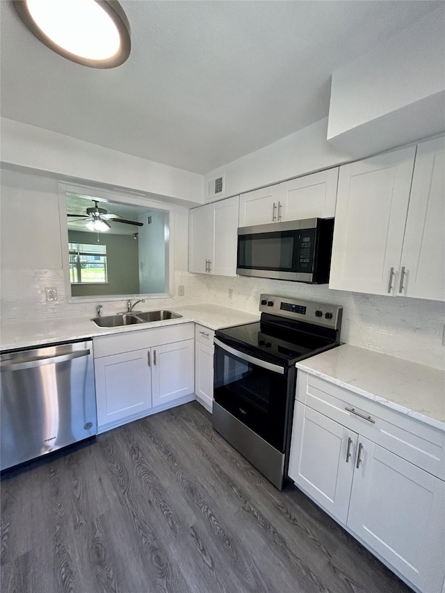 kitchen with visible vents, white cabinets, appliances with stainless steel finishes, dark wood-style flooring, and a sink