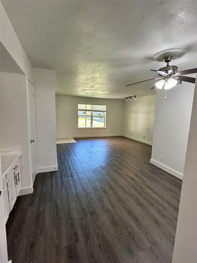 3616 Parkridge Dr Unit 108, Dallas, TX 75234 - unfurnished living room featuring dark wood-style floors, baseboards, a textured ceiling, and ceiling fan