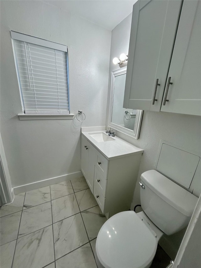 3616 Parkridge Dr Unit 108, Dallas, TX 75234 - half bathroom with baseboards, marble finish floor, toilet, vanity, and a textured wall