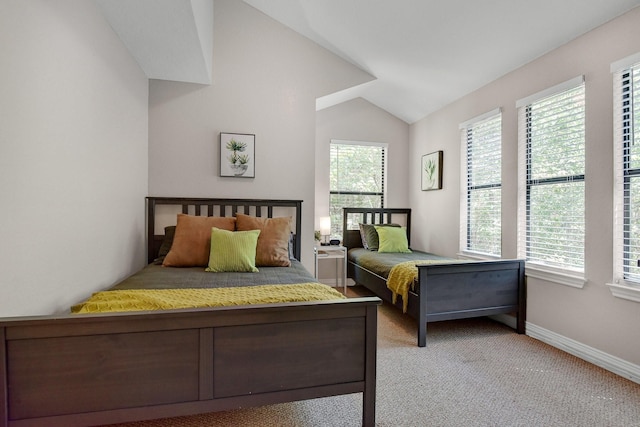 carpeted bedroom featuring lofted ceiling and baseboards