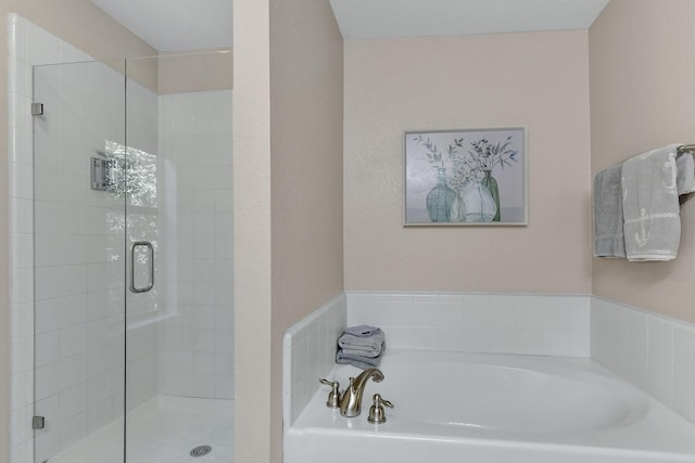 bathroom with a garden tub and a shower stall