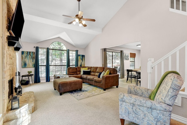 carpeted living area with high vaulted ceiling, a ceiling fan, and stairs