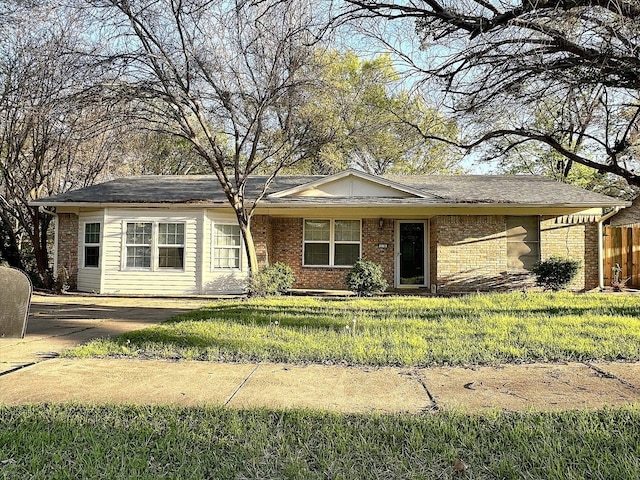 ranch-style home with a front yard and brick siding