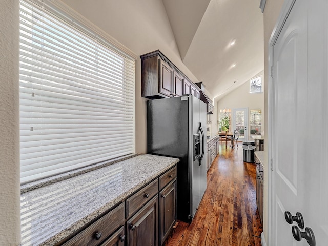 kitchen featuring light stone counters, a notable chandelier, dark brown cabinets, stainless steel fridge with ice dispenser, and dark wood finished floors