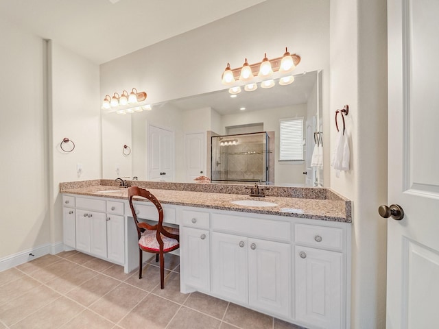 bathroom with double vanity, a stall shower, tile patterned flooring, and a sink