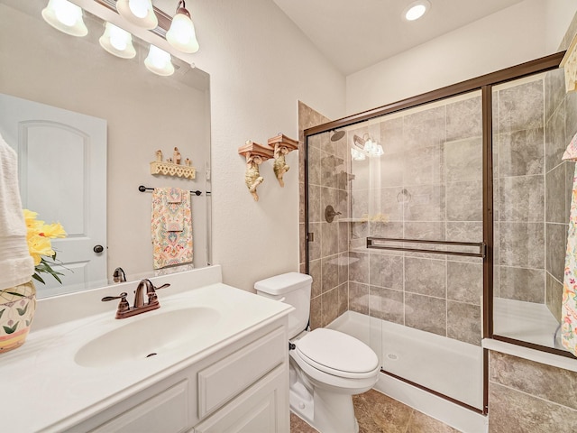 full bath featuring toilet, a stall shower, and vanity