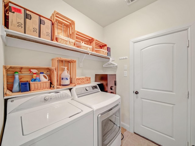 washroom with laundry area, light tile patterned floors, and separate washer and dryer