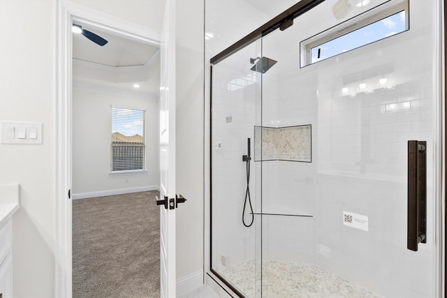 full bath with a stall shower, a healthy amount of sunlight, crown molding, and baseboards