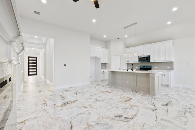 kitchen featuring visible vents, decorative backsplash, appliances with stainless steel finishes, white cabinets, and a sink