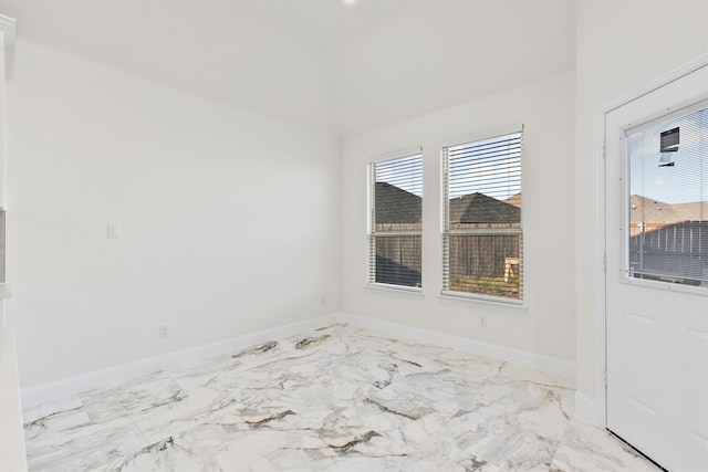 unfurnished room featuring marble finish floor and baseboards