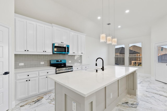 kitchen with marble finish floor, stainless steel appliances, tasteful backsplash, white cabinets, and a sink