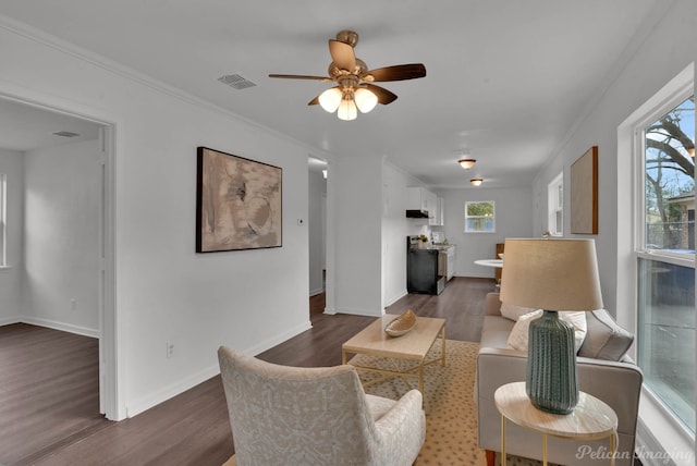 living area featuring ornamental molding, dark wood-type flooring, visible vents, and baseboards