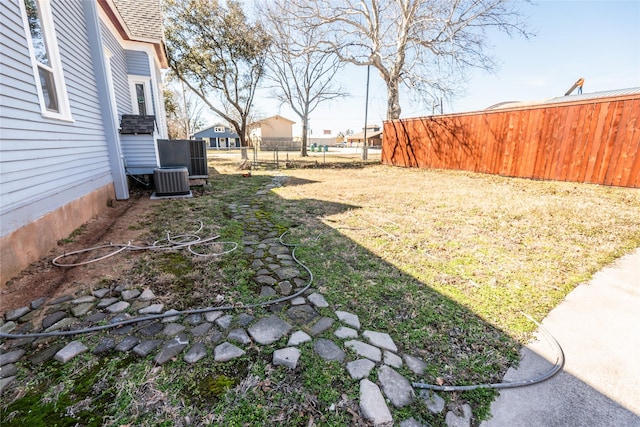 view of yard featuring fence and central AC unit