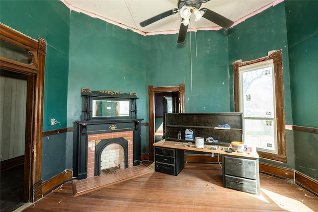 kitchen with ceiling fan, a tile fireplace, wood finished floors, and baseboards