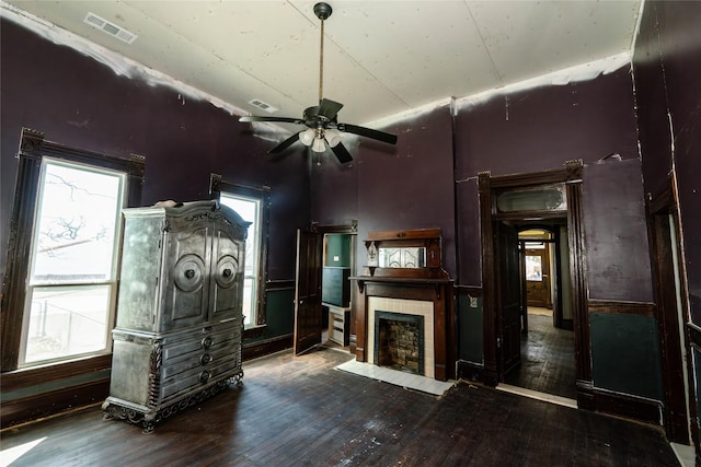 unfurnished living room featuring wood-type flooring, visible vents, and a tiled fireplace