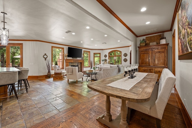 dining area with baseboards, ornamental molding, healthy amount of natural light, recessed lighting, and a tiled fireplace