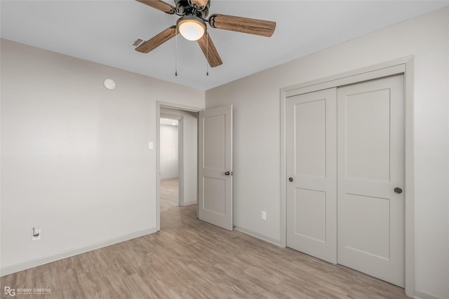 unfurnished bedroom featuring a closet, visible vents, light wood-style floors, ceiling fan, and baseboards