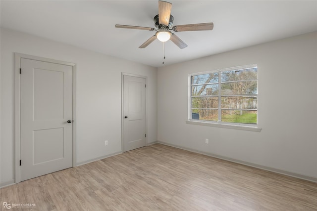 spare room featuring baseboards, a ceiling fan, and wood finished floors