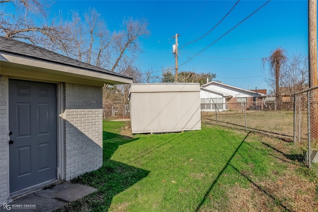 view of yard featuring fence, a storage unit, and an outdoor structure