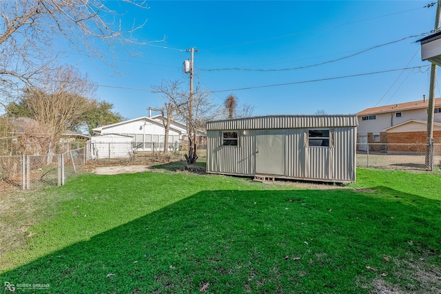 view of yard with a storage shed, a fenced backyard, and an outdoor structure