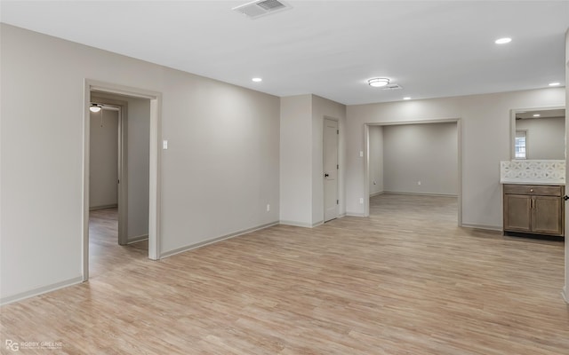 spare room featuring baseboards, light wood-type flooring, visible vents, and recessed lighting