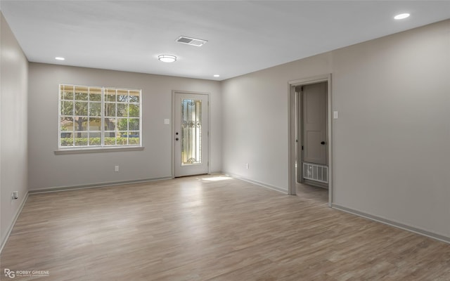 spare room with baseboards, light wood-style flooring, visible vents, and recessed lighting