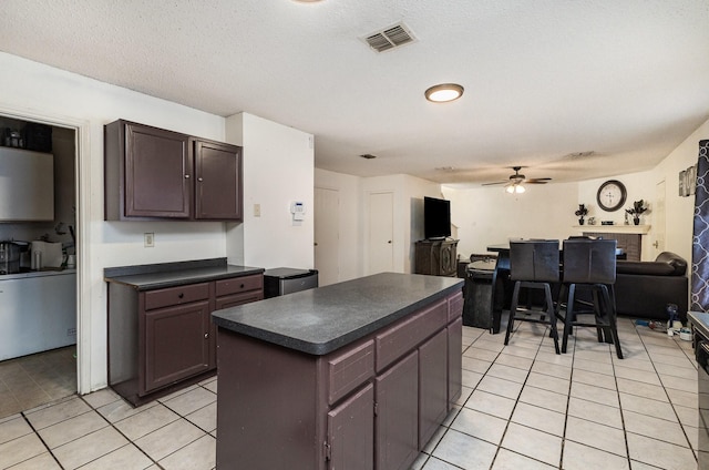 kitchen with a ceiling fan, dark countertops, visible vents, and light tile patterned floors