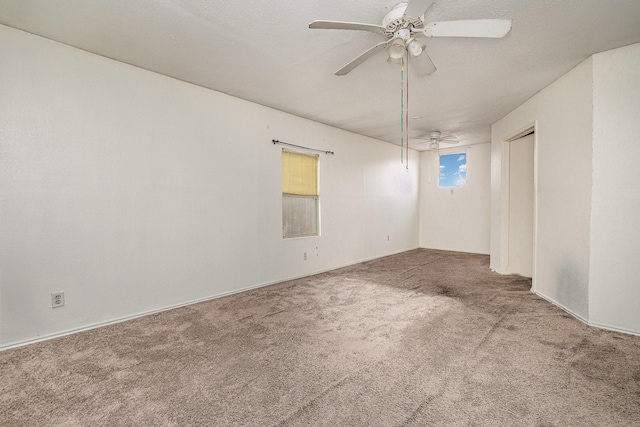 carpeted empty room featuring ceiling fan and a textured ceiling