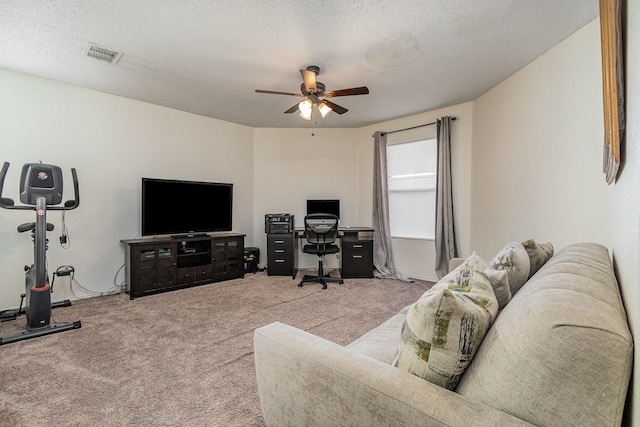 living area with ceiling fan, a textured ceiling, carpet flooring, and visible vents