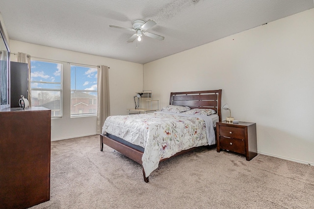bedroom featuring ceiling fan, a textured ceiling, baseboards, and carpet flooring