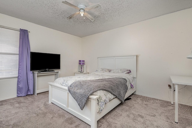 carpeted bedroom featuring a textured ceiling, ceiling fan, and baseboards