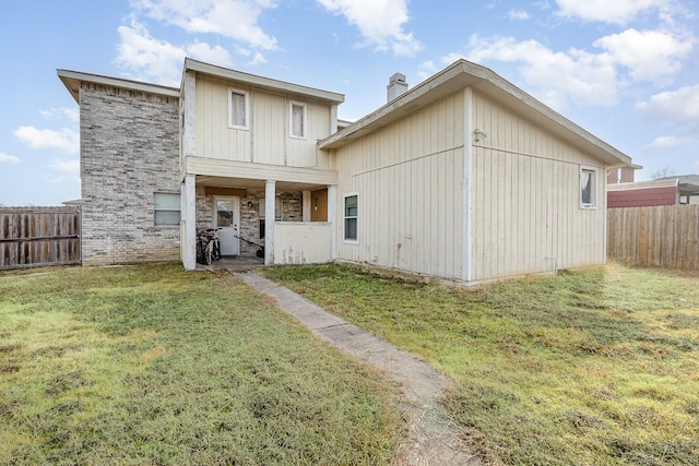 view of front of house featuring a front yard, a chimney, and fence private yard