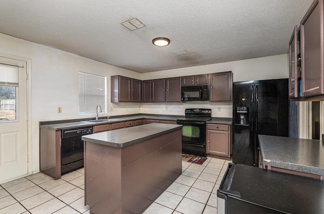 kitchen featuring dark countertops, visible vents, black appliances, and light tile patterned floors