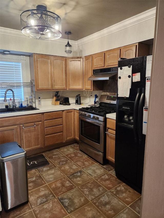 kitchen with stainless steel gas range oven, crown molding, black fridge, under cabinet range hood, and a sink