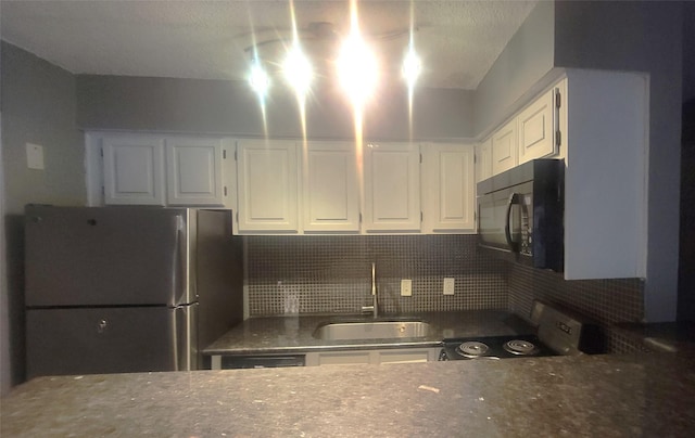 kitchen with freestanding refrigerator, white cabinetry, a sink, range with electric cooktop, and black microwave