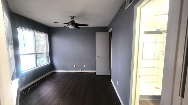 spare room with a ceiling fan, dark wood-style flooring, and baseboards