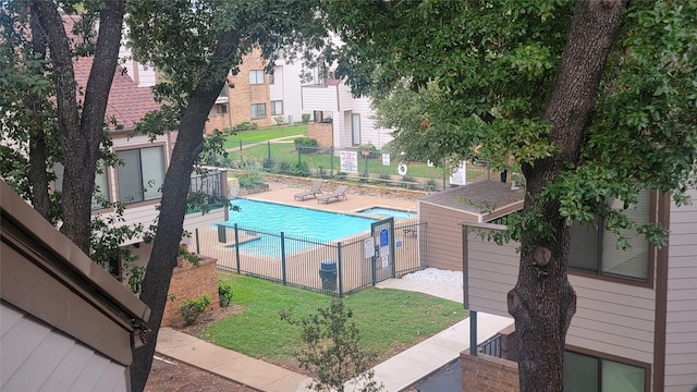 community pool with a lawn and fence