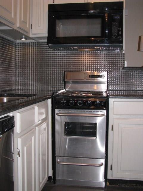 kitchen with appliances with stainless steel finishes, white cabinetry, and decorative backsplash