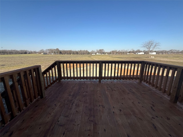 wooden terrace featuring a rural view and a lawn