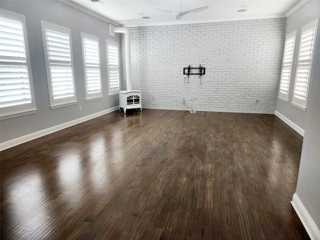 612 Skyline Bluff Dr, Fort Worth, TX 76102 - unfurnished living room featuring brick wall, crown molding, a wood stove, wood finished floors, and ceiling fan